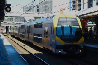 A modern city train arrives at a busy station in Sydney, Australia.